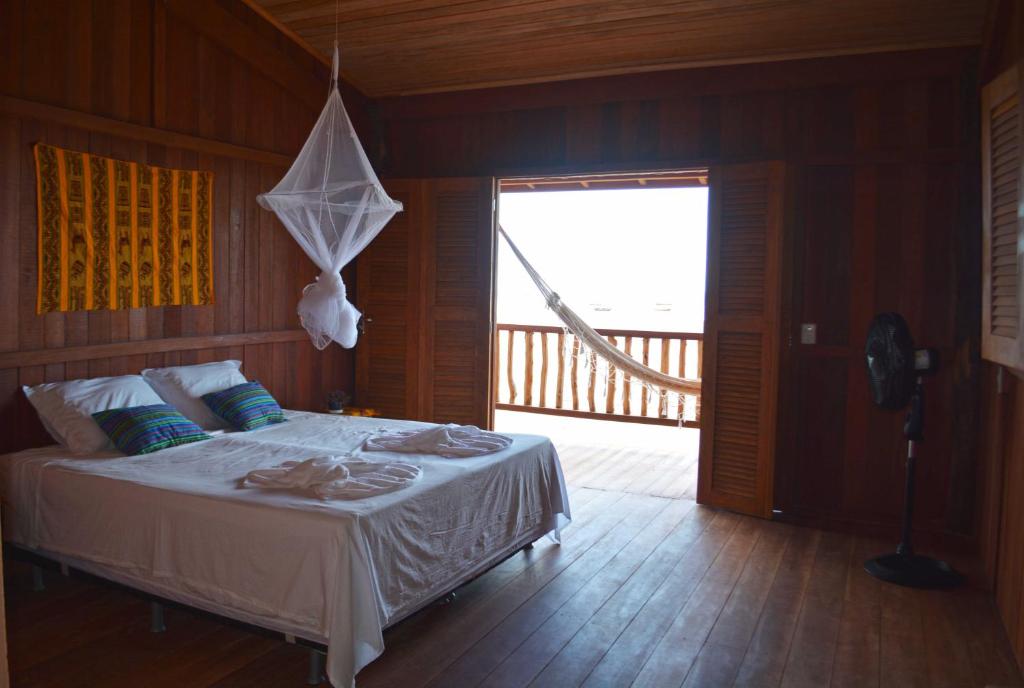 a bedroom with a bed and a large window at Casa Dunas da Barrinha in Barrinha