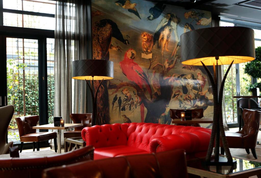 a living room with a red couch and a colorful wall at Restaurant Hotel Merlet in Schoorl