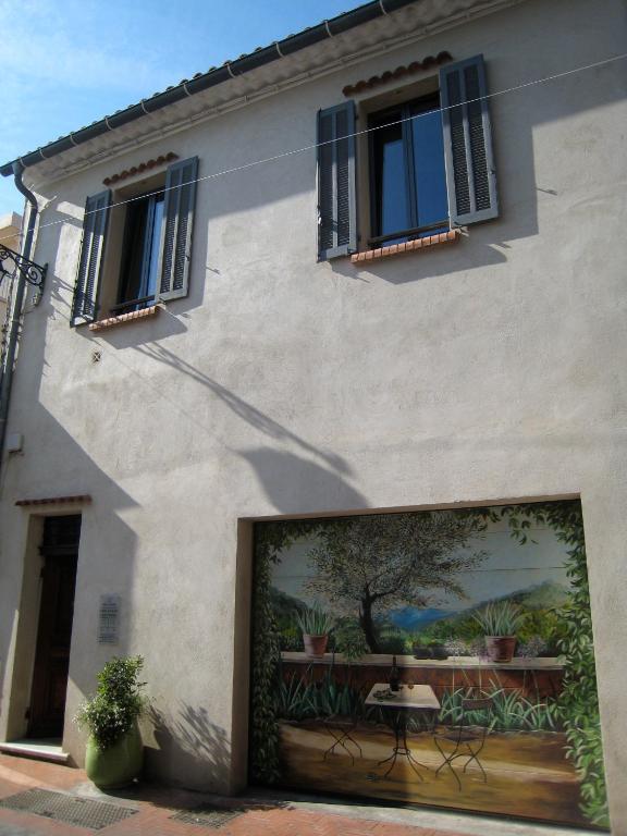 a building with a large door with a painting on it at StellaHome - La petite cour in Sanary-sur-Mer