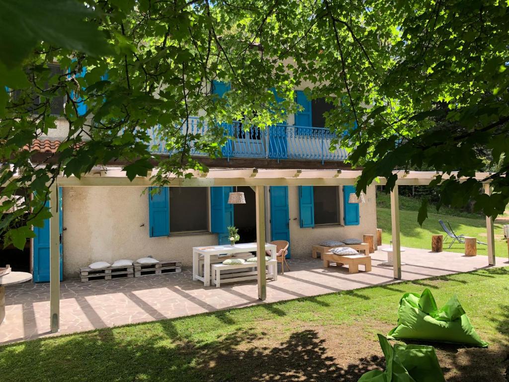 una casa con porche y casa azul en Agriturismo La Casa Nel Bosco, en Boveglio