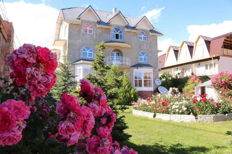 a large house with pink flowers in front of it at Гостевой дом "Ысык-Куль - Светлана" in Cholpon-Ata