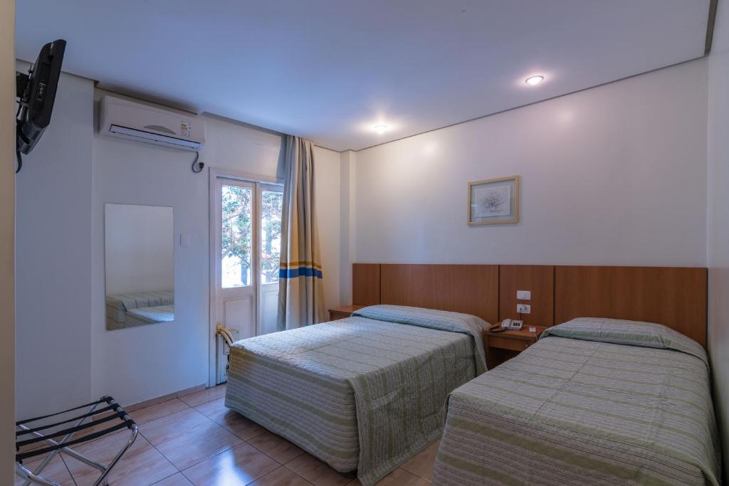 a room with two beds and a window at Cinelandia Hotel in Sao Paulo