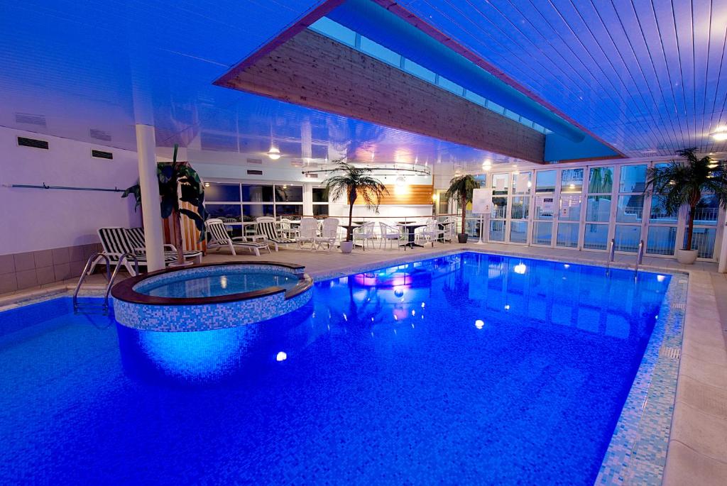 a swimming pool in a hotel with a blue lighting at Le Robinson in Saint-Jean-de-Monts