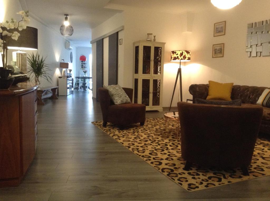 a living room with couches and chairs and a rug at Les Halles Chambre D'hôtes in Verteuil-sur-Charente