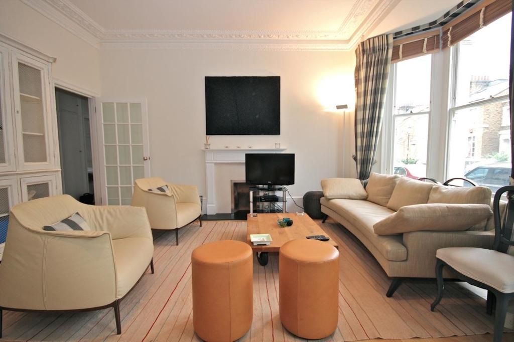 ロンドンにあるCanguroProperties - Gertrude Streetのリビングルーム(ソファ、椅子、テレビ付)