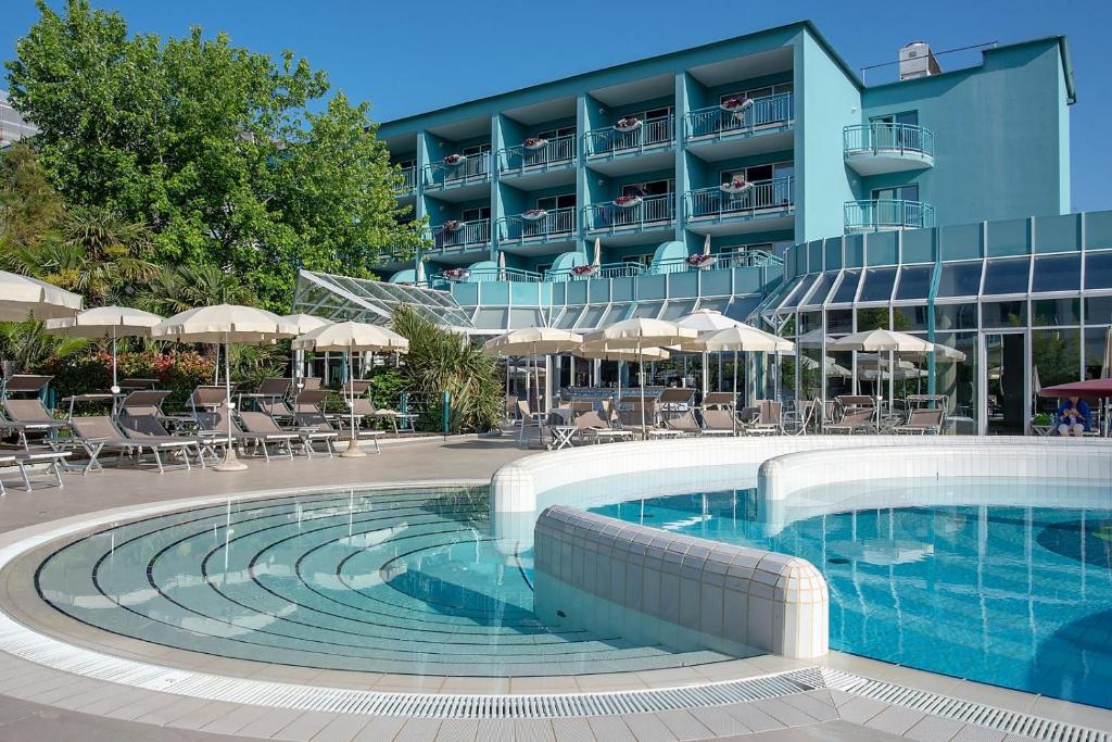 a swimming pool in front of a hotel at Hotel Savoy in Grado