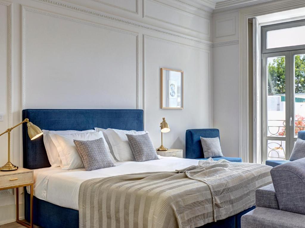 a bedroom with a large bed with a blue headboard at Porto Downtown Lovers Suites: Bombarda 451 in Porto