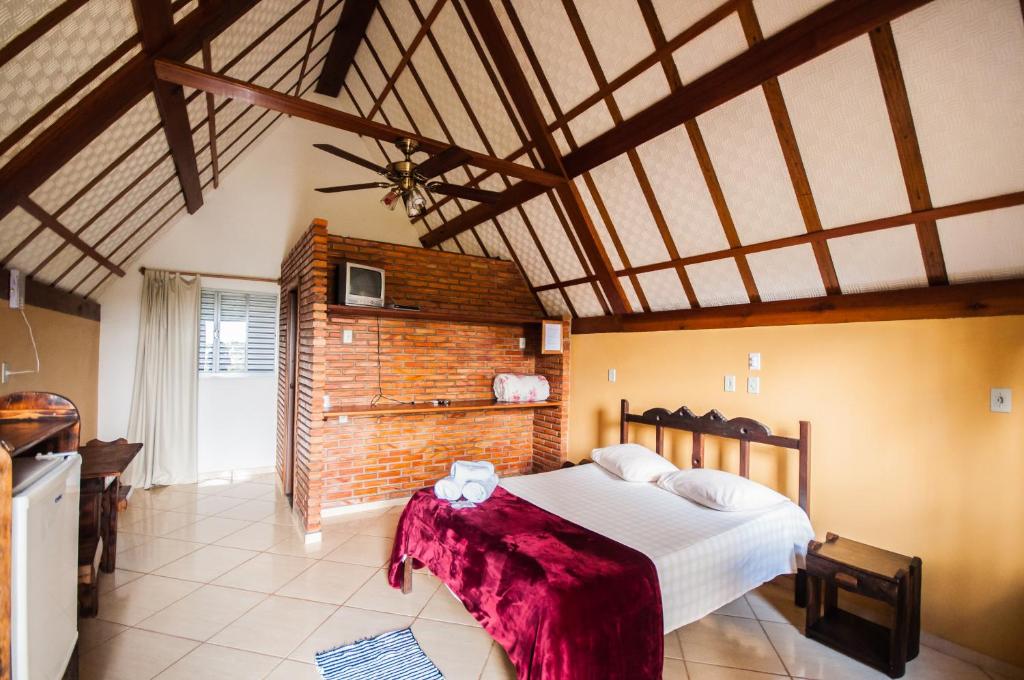 een slaapkamer met een groot bed in een kamer bij Pousada das Nascentes in Catas Altas