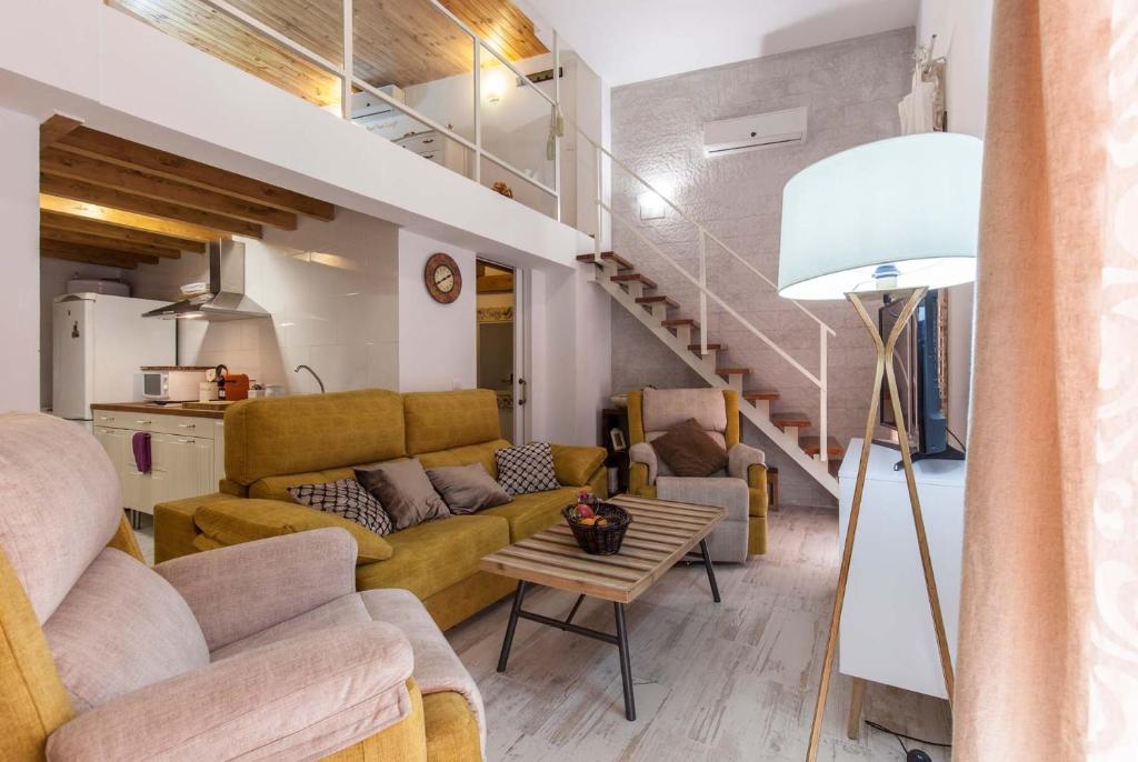 ein Wohnzimmer mit einem Sofa und einem Tisch in der Unterkunft Loft / Duplex with charming historic center. WIFI in Sevilla