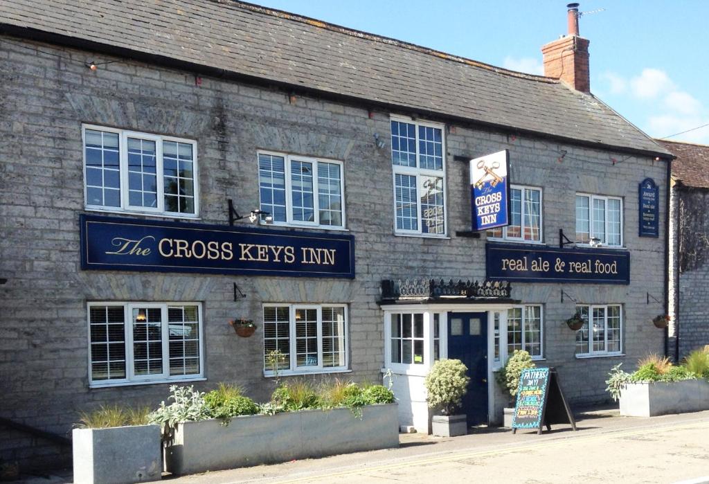 a brick building with a sign that reads the cross keys inn at Cross Keys Inn in East Lydford