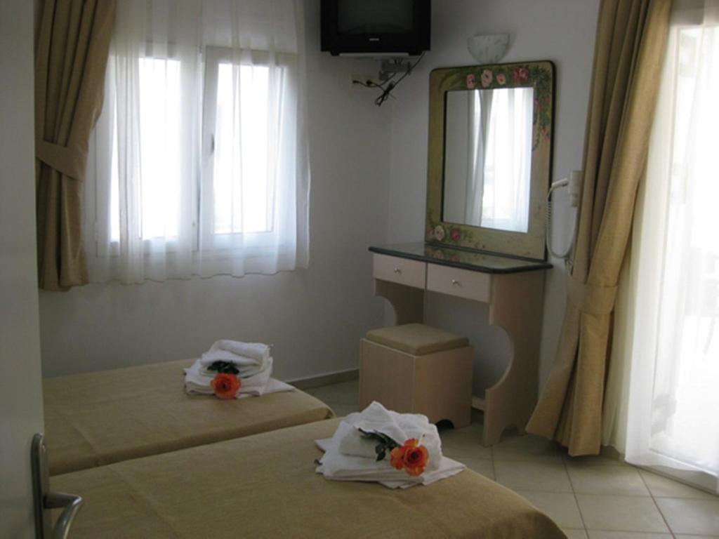 a bedroom with two beds and a mirror and a sink at Manto Studios in Palaiochora