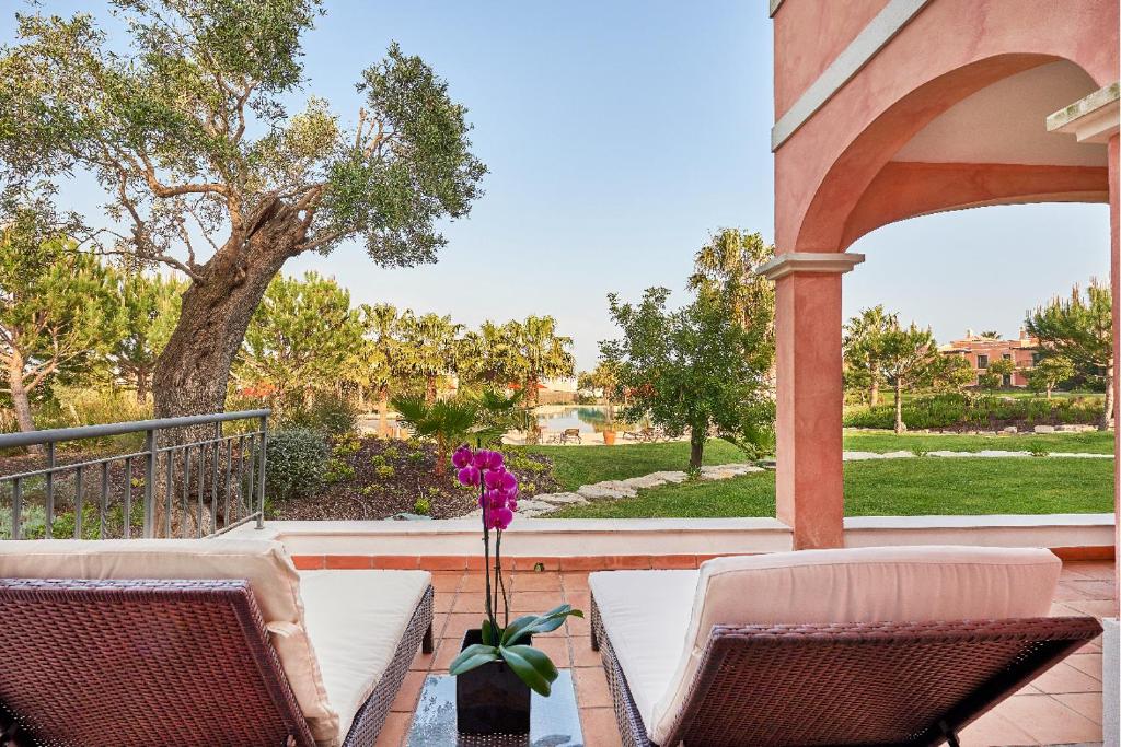 a patio with two chairs and a table with a flower in a vase at Cascade Wellness Resort in Lagos