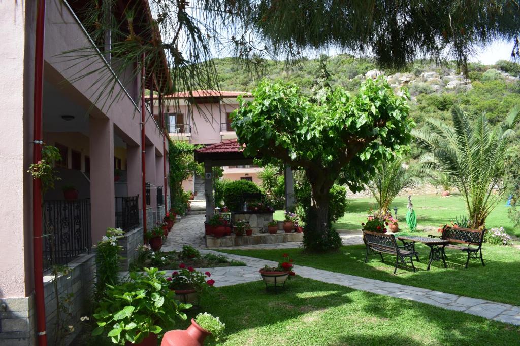 a courtyard of a house with a table and a tree at House Evristhenis 2 in Toroni