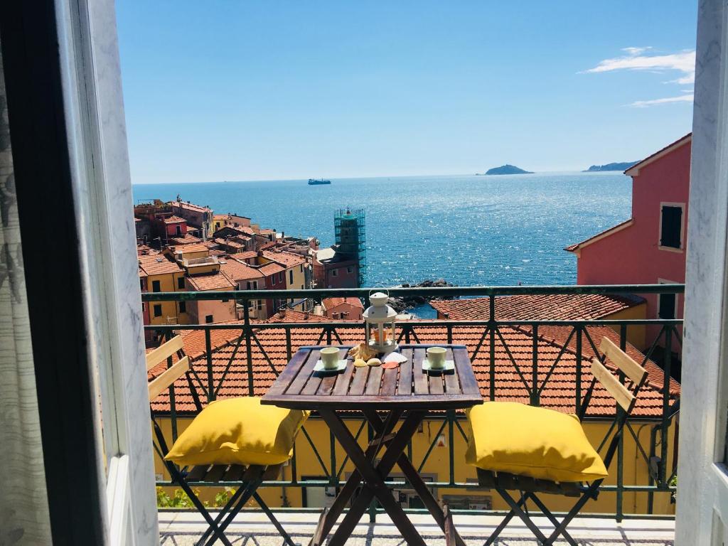 una mesa en un balcón con vistas al agua en Vento di Mare, en Tellaro