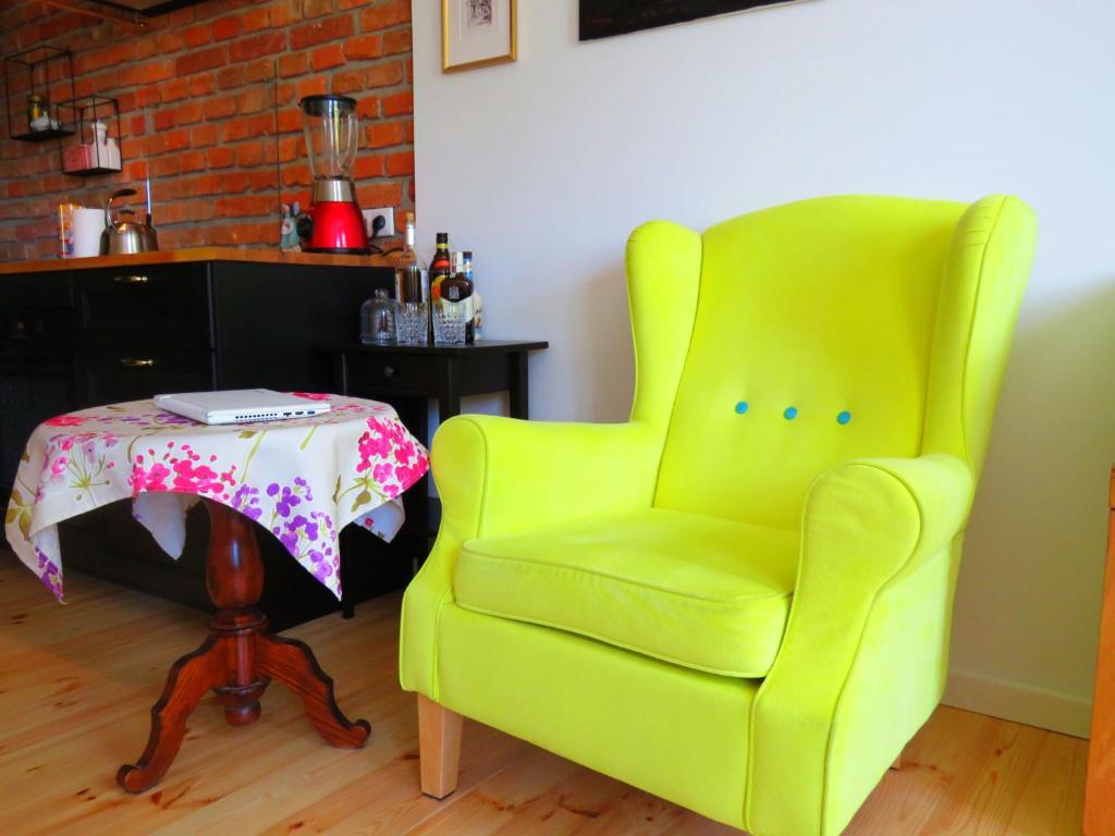 a yellow chair with a table in a room at Ratuszowa 18 in Olsztynek