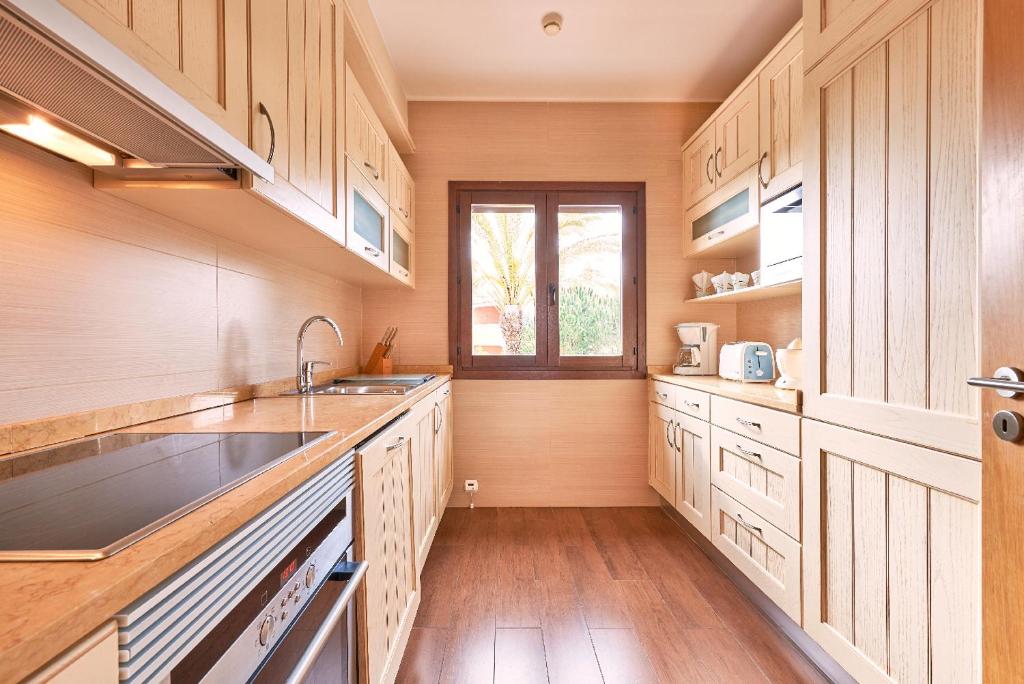 a kitchen with wooden cabinets and a sink and a window at Cascade Wellness Resort in Lagos