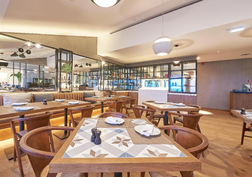 a restaurant with wooden tables and wooden chairs at Cascade Wellness Resort in Lagos