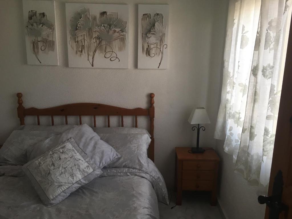 a bedroom with a bed and three pictures on the wall at Casa Phoenix Bed & Breakfast in La Marina
