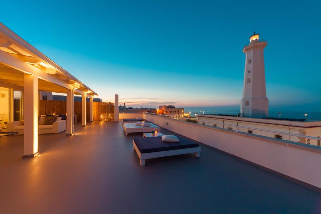 um farol no telhado de um edifício com bancos em Casa del Faro em Torre Canne