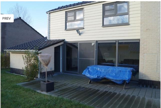 ミッデルケルケにあるZee en polder nummer 16のデッキ上の青いテーブル付きの家
