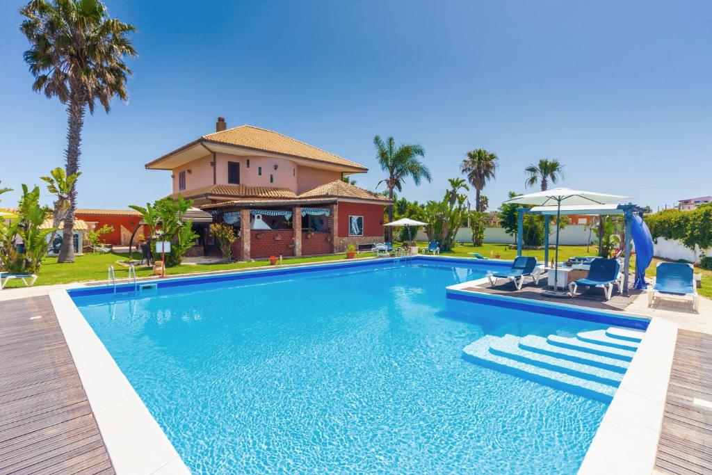 a swimming pool in front of a house at B&B Sicilia Bella in Cassibile