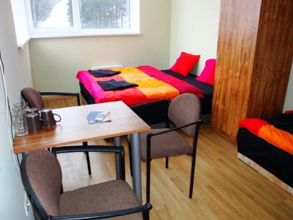 Habitación con cama, mesa y sillas. en Hotel Můstek en Liberec