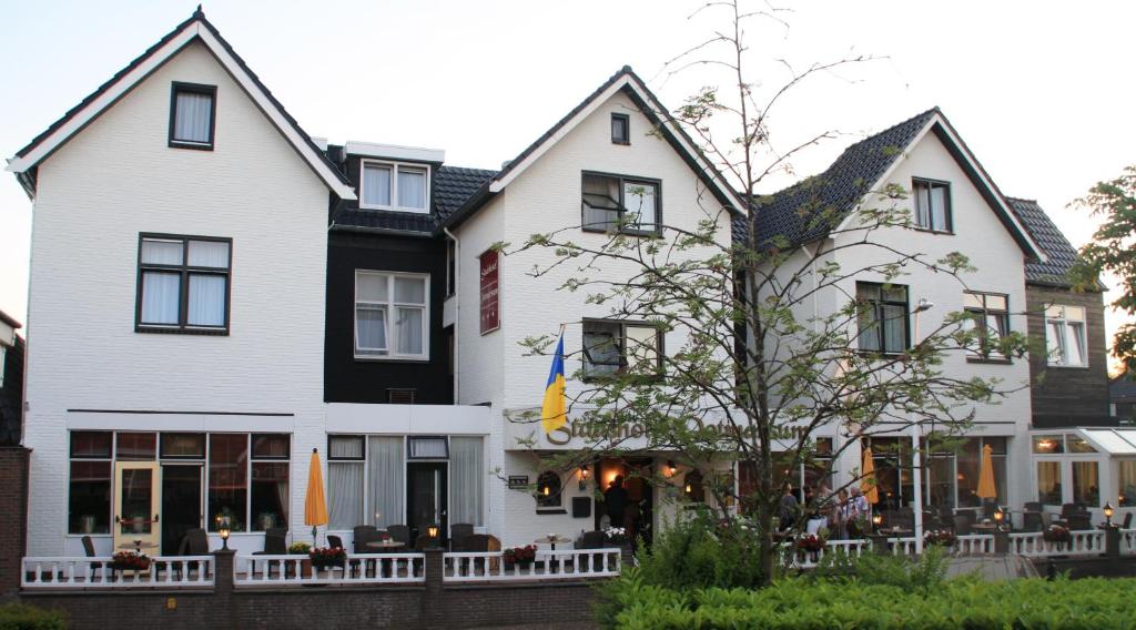 een wit en zwart gebouw met een restaurant bij Stadshotel Ootmarsum in Ootmarsum