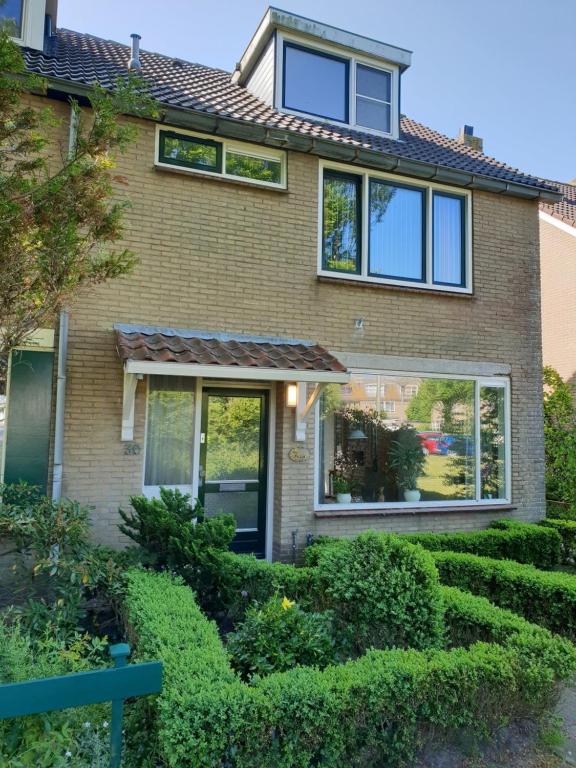 une maison avec des buissons devant elle dans l'établissement Sabai Sabai Huis, à Egmond aan den Hoef