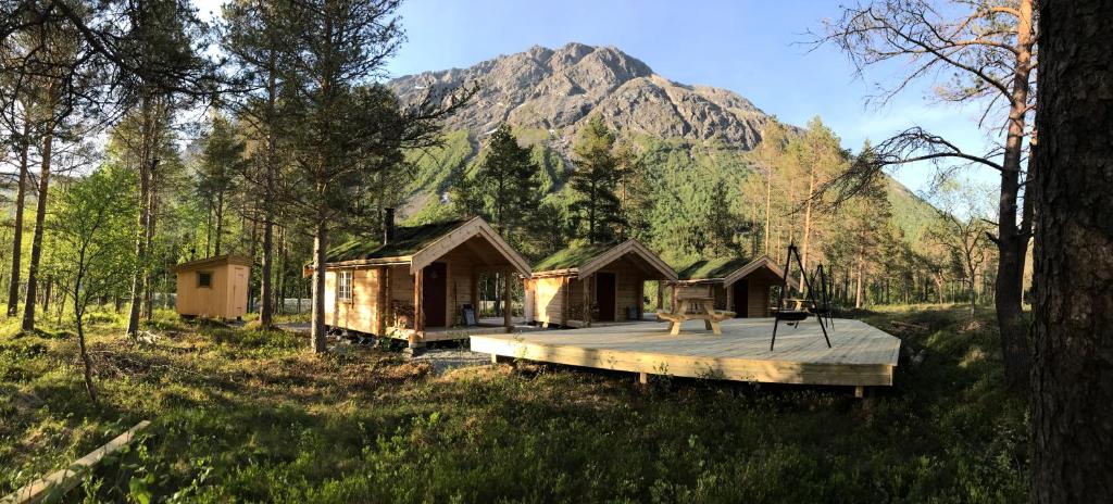 a cabin in the woods with a mountain in the background at Camp Dronningkrona in Ålvundeid