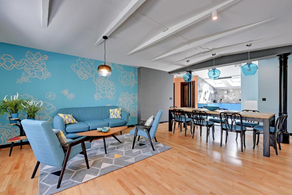 ソポトにあるSopot Comfort Apartments Superiorのリビングルーム(青いソファ、テーブル、椅子付)