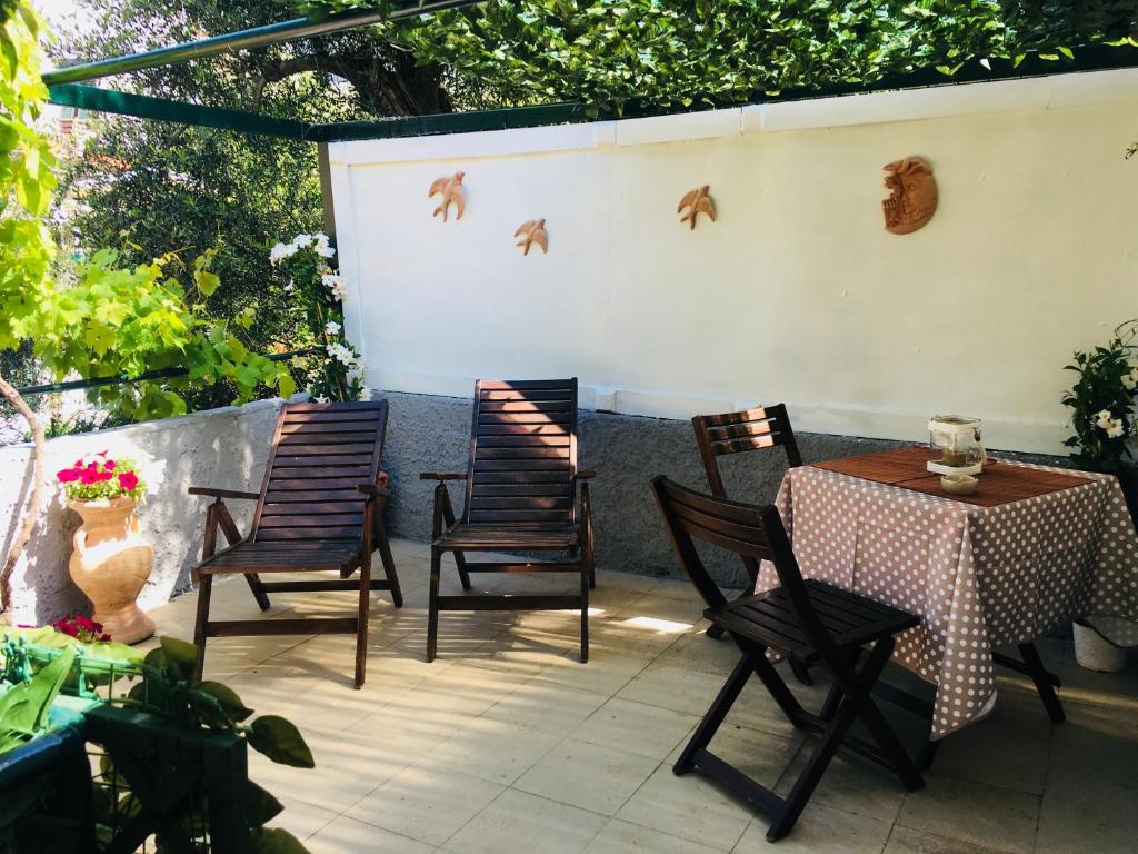 um pátio com 4 cadeiras e uma mesa com uma mesa em Il Giardino Segreto em Tellaro