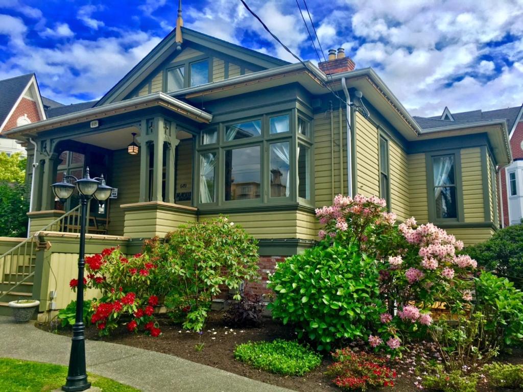 una casa amarilla con flores delante en Robert Porter House Inn, en Victoria