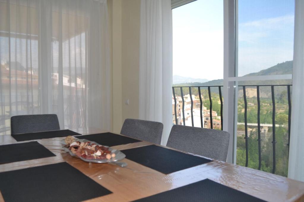 een eetkamer met een tafel met stoelen en een balkon bij Vive Montanejos! in Montanejos