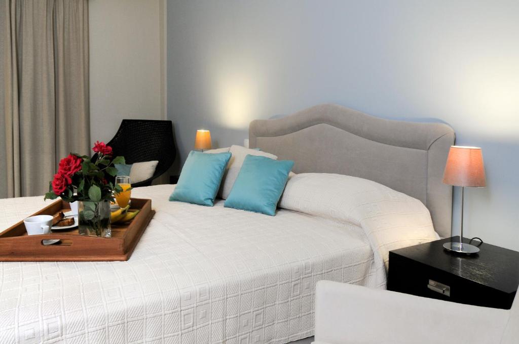 1 dormitorio con cama blanca y almohadas azules en Athena Hotel, en Milopótamos