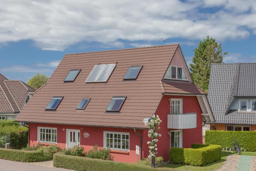 a red house with solar panels on the roof at Ferienhaus Lütten Kulli - 1 in Zingst