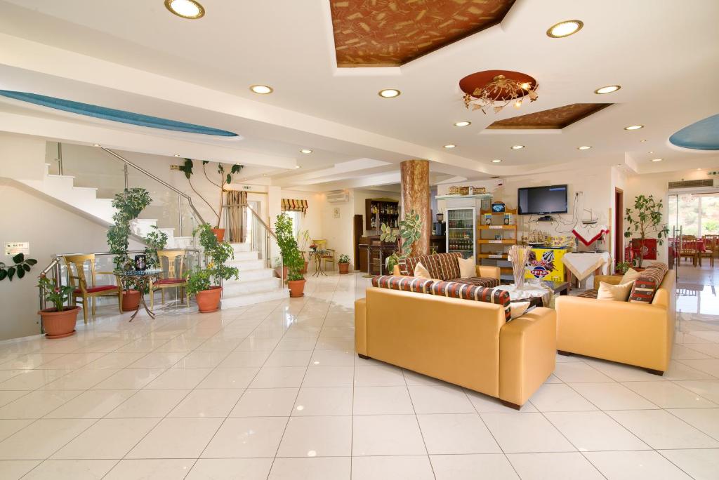 a large living room with couches and tables at Hotel Diamond in Limenaria