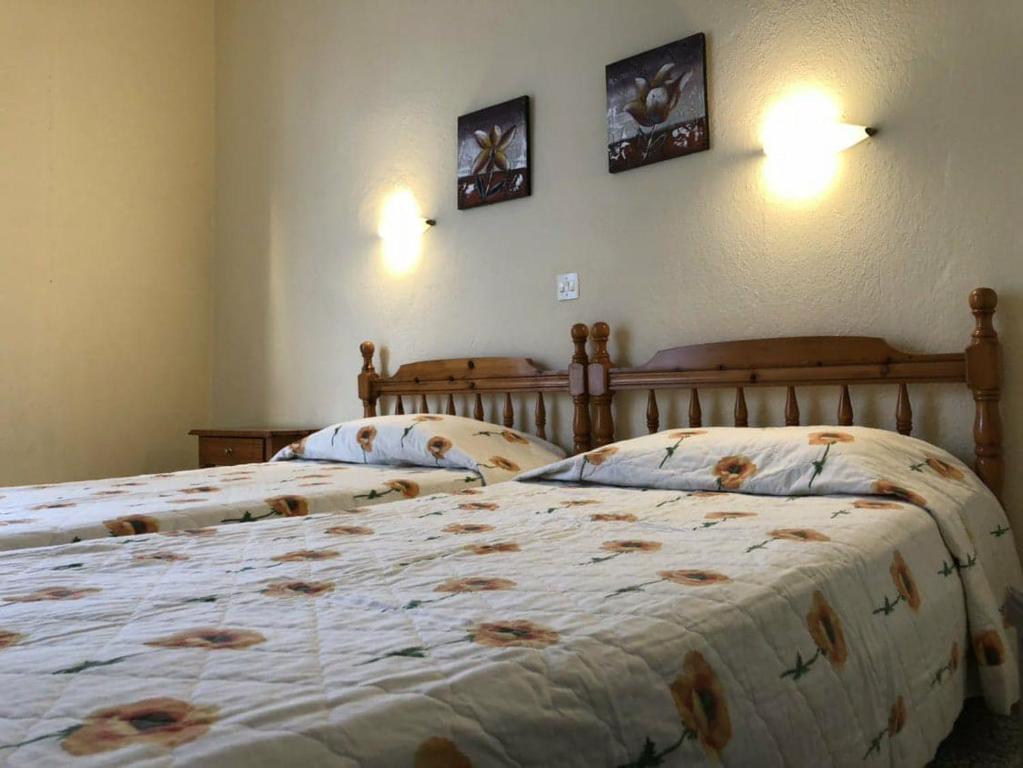 スカラ・ソティロスにあるAnna Georgiouのツインベッド2台(壁に2つの柱式ベッドが掛けられたベッドルーム内)