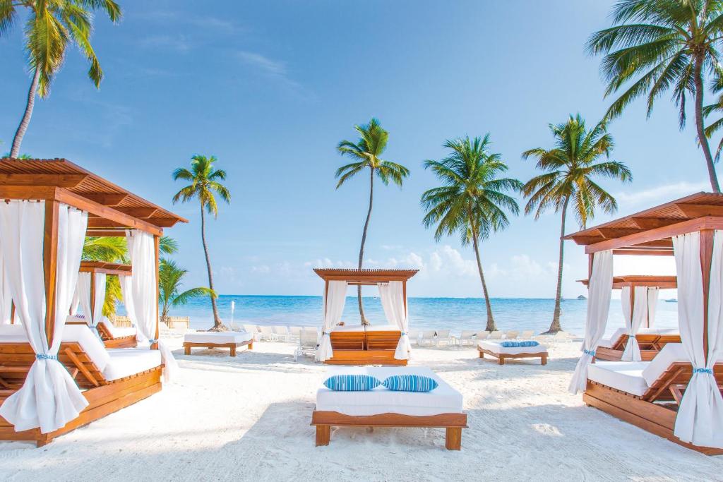 a beach area with chairs, tables and umbrellas at Be Live Collection Punta Cana Adults Only in Punta Cana