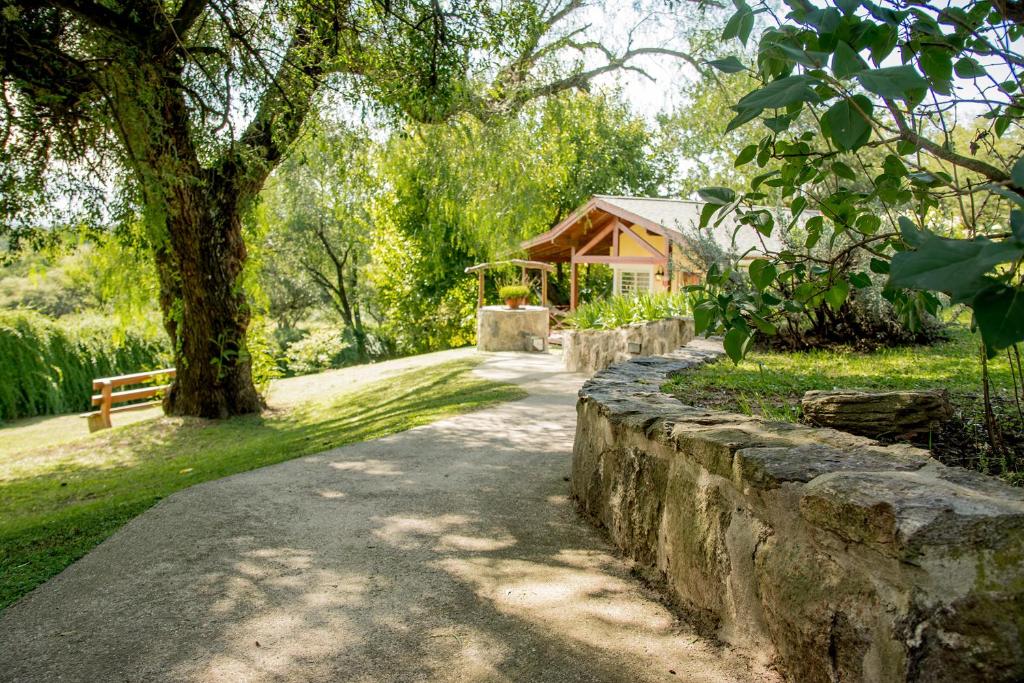 a stone path in front of a house with a tree at Del Arroyo Cabañas in Villa General Belgrano