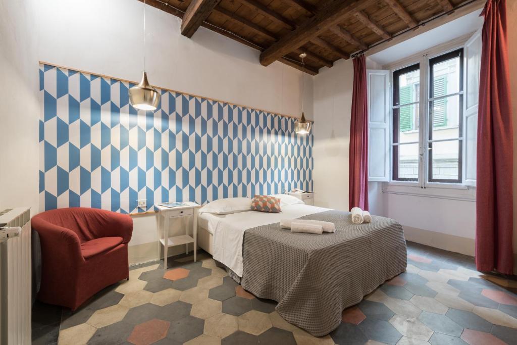 1 dormitorio con 1 cama y 1 silla en F7 - Santa Croce one bedroom flat for 2 or 3 guests, en Florencia