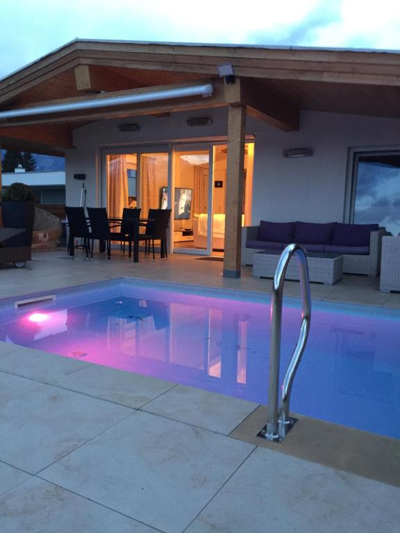 una piscina con illuminazione viola di fronte a una casa di Haus Eibl a Seefeld in Tirol