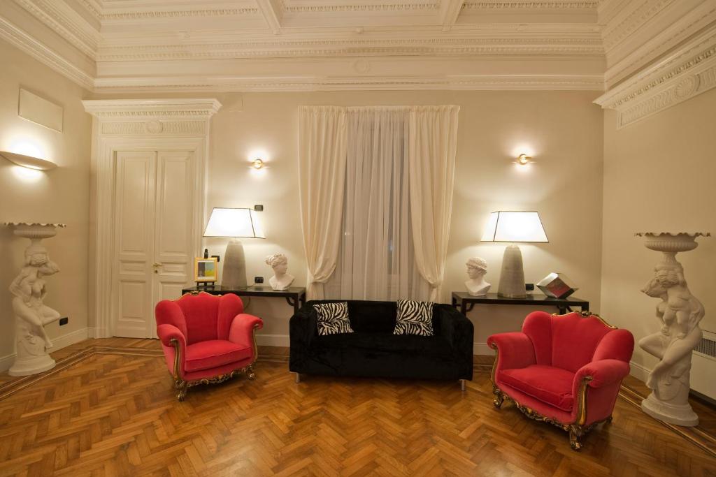 een woonkamer met 2 rode stoelen en een bank bij Palazzo Lombardo in Florence