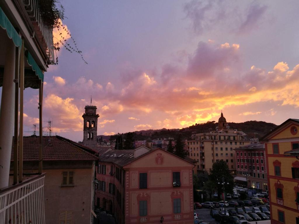 a sunset over a city with a clock tower at La Torre Civica in Rapallo