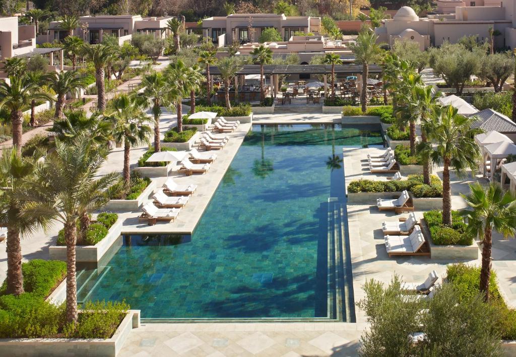 an aerial view of a resort pool with lounge chairs and palm trees at Four Seasons Resort Marrakech in Marrakesh