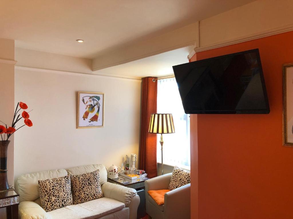 a living room with a flat screen tv on a wall at Arun Sands Rooms in Littlehampton