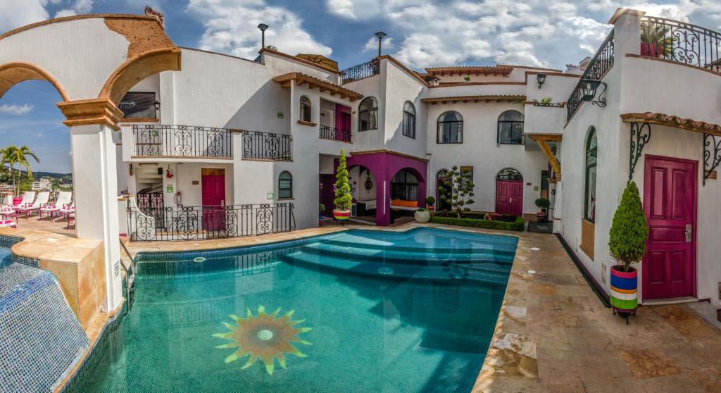 a large house with a swimming pool in front of it at Boutique Pueblo Lindo in Taxco de Alarcón
