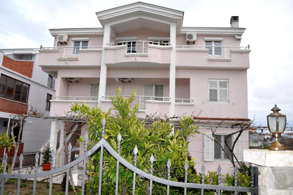 a white house with a fence in front of it at Apartments Perezaj in Ulcinj