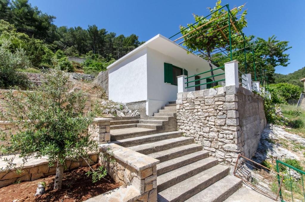 een huis met een trap en een stenen muur bij House Filip in Bogomolje