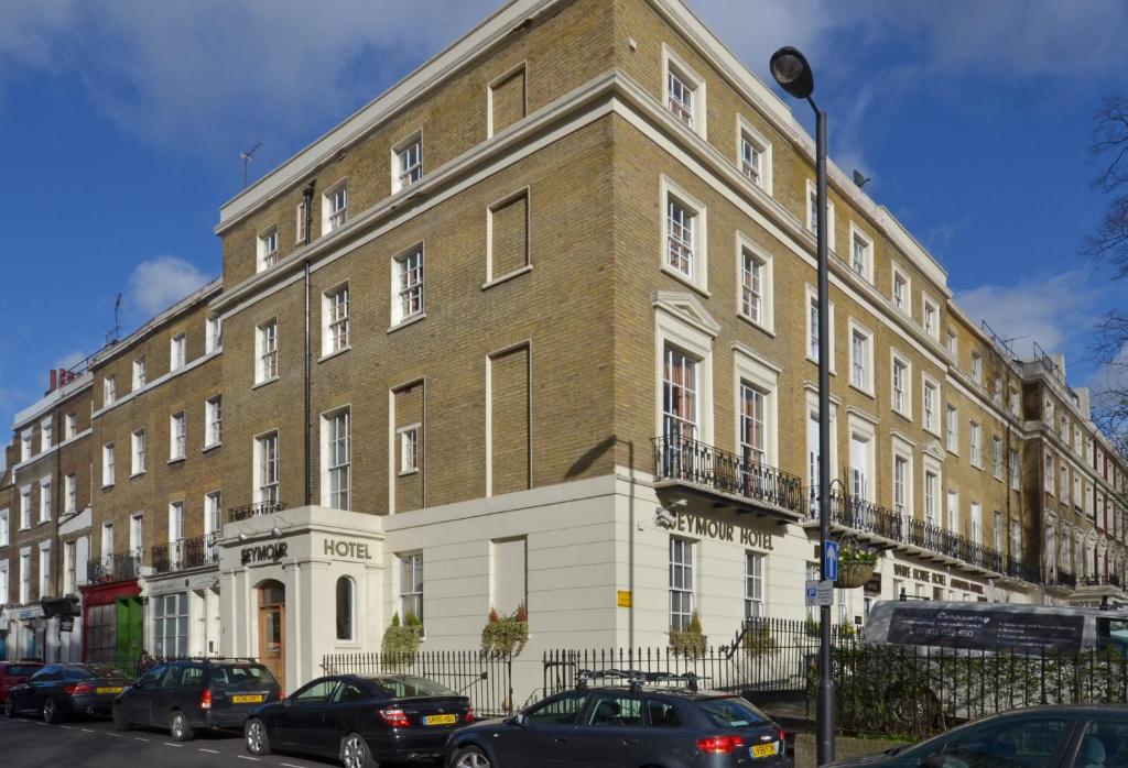 a large brick building with cars parked in front of it at Seymour Hotel in London