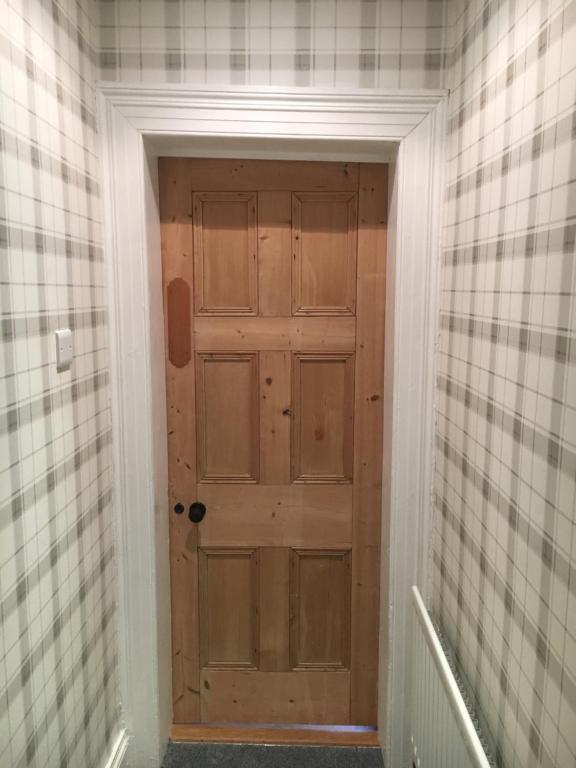 a hallway with a wooden door in a room at The Carrick in Portrush